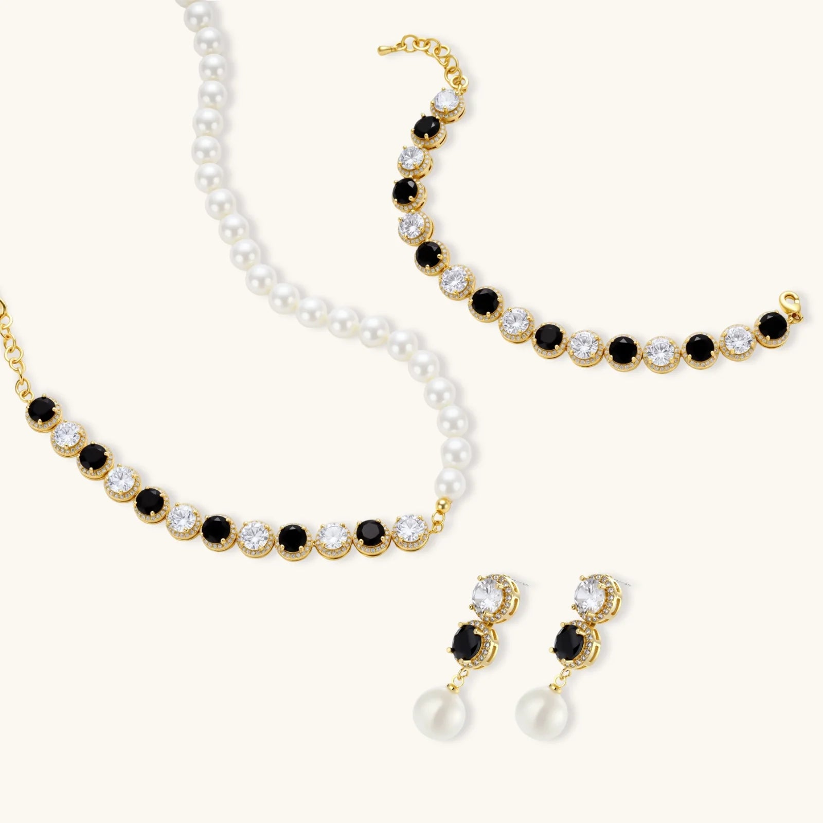 Gold-plated jewelry set with alternating black and clear cubic zirconia stones, featuring necklace, earrings and bracelet