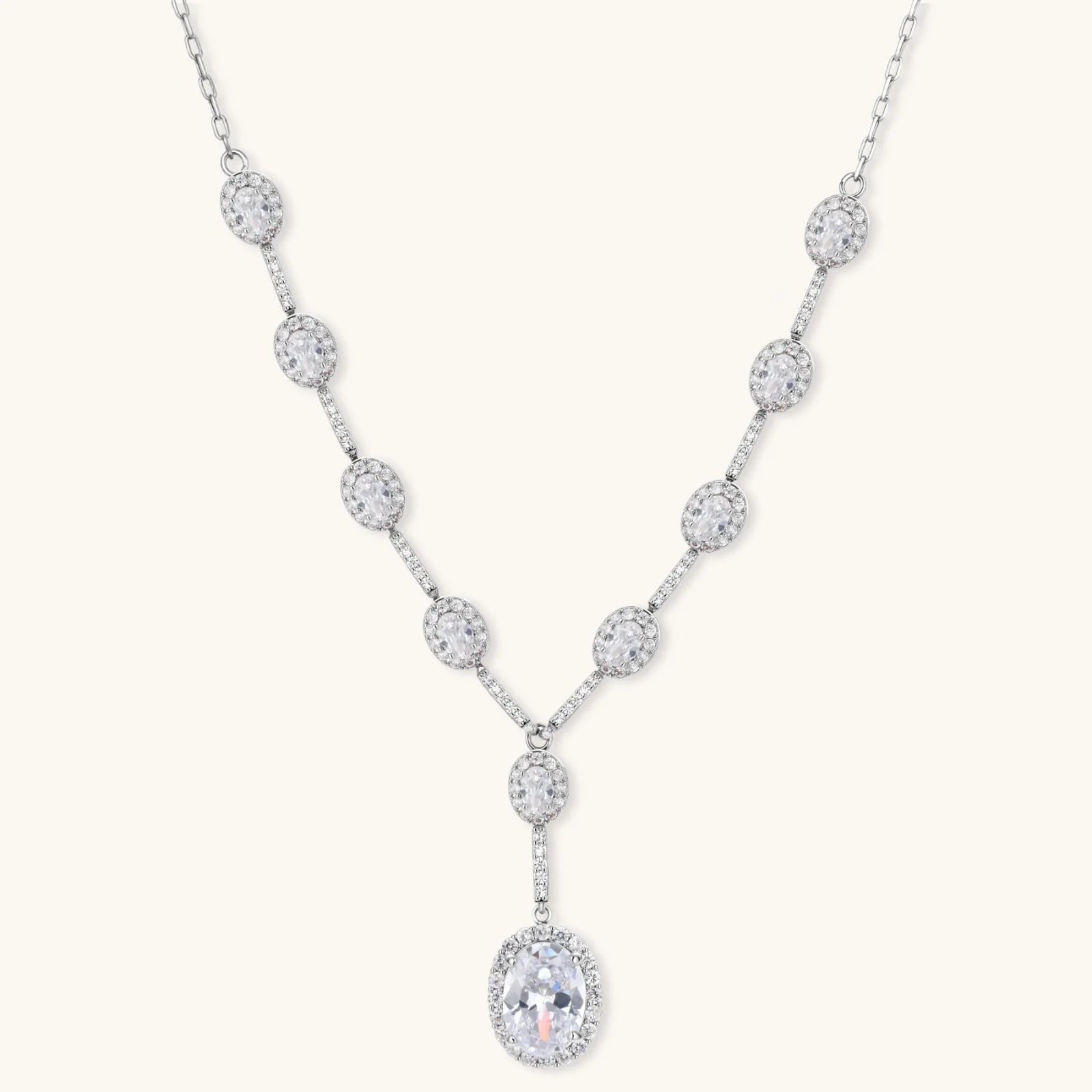 Elegant white gold plated jewelry set with oval cubic zirconia stones in halo settings, featuring Y-necklace and drop earrings.