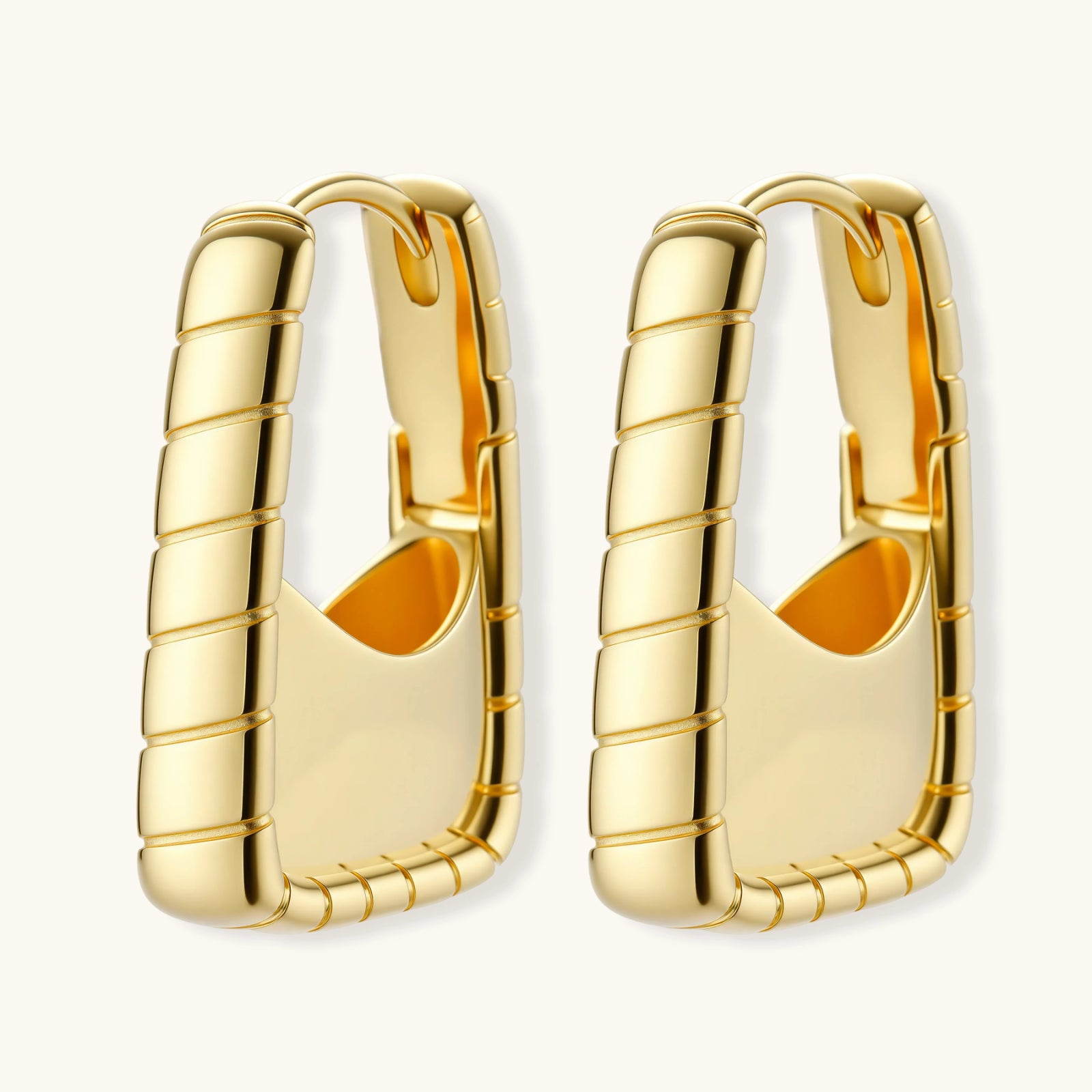 Chunky segmented gold-plated huggie hoop earrings with bamboo-inspired geometric design on white background.