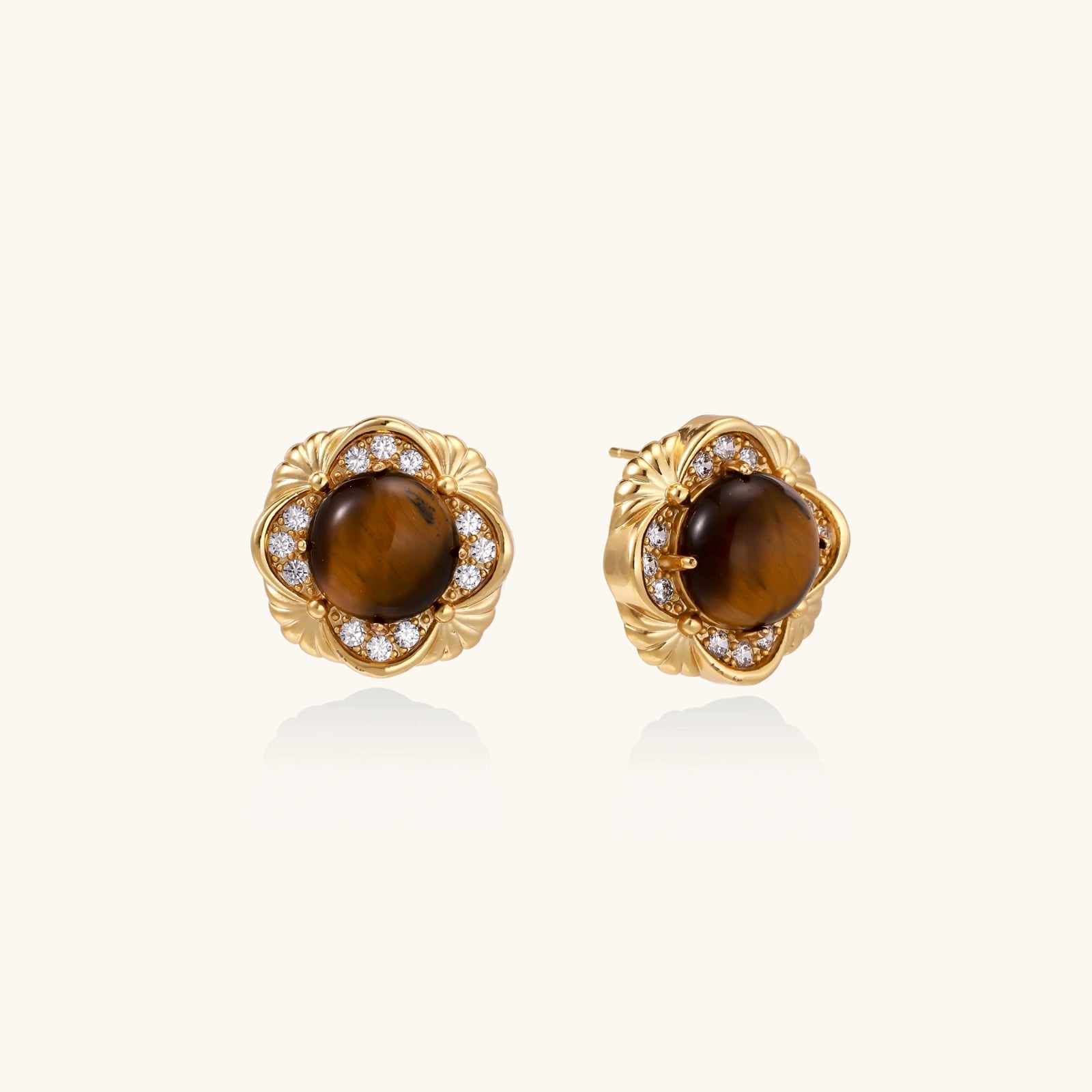 Gold-plated stud earrings with ornate floral frames surrounding cabochon tiger's eye stones and zirconia accents