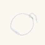 Minimalist bracelet with iridescent baroque pearl on rhodium-plated sterling silver chain against cream background