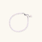 Adjustable bracelet featuring lustrous freshwater pearls with rhodium-plated sterling silver clasp on cream background.