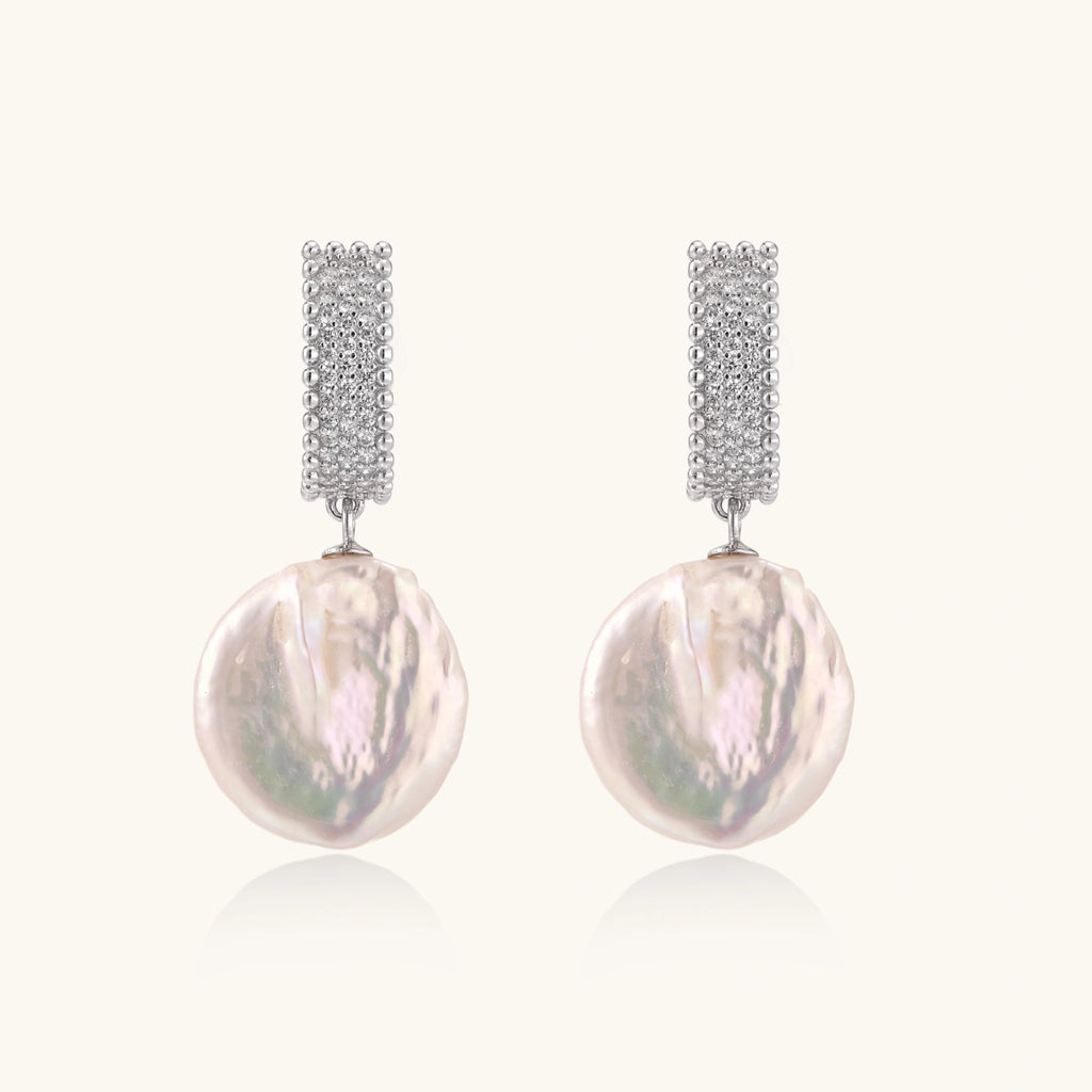 Rhodium-plated silver curved stud with pave stones and baroque pearl drop on white background