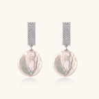 Rhodium-plated silver curved stud with pave stones and baroque pearl drop on white background