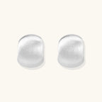 Brushed sterling silver cushion-shaped stud earrings with matte finish on white background