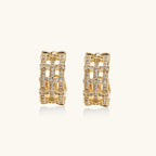 Gold-plated geometric hoop earrings with basket-weave lattice design and pavé crystal accents on cream background