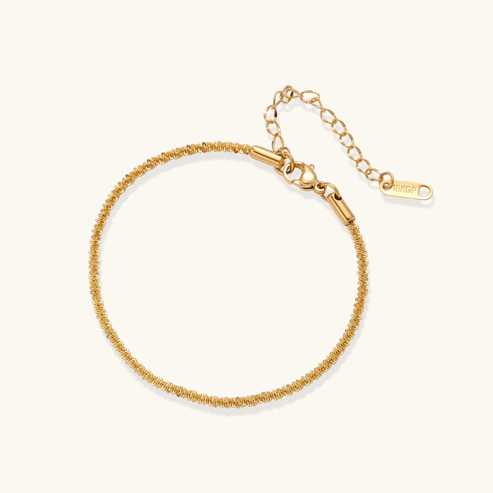 Delicate 18K gold-plated stainless steel bracelet with textured beaded chain on cream background