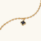 18K gold-plated oval bead chain bracelet with quatrefoil clover charm featuring mother of pearl inlay on cream background