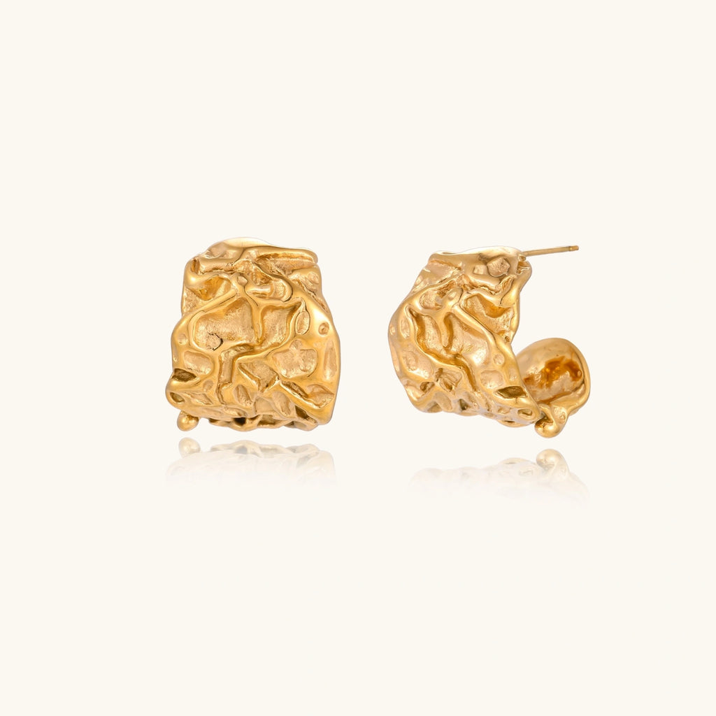 Chunky gold-plated hoop earrings with organic crumpled texture on cream background, 21.5mm sculptural design