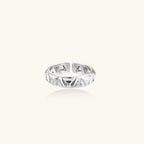 White gold adjustable ring with geometric triangle cutouts and zirconia stones on cream background